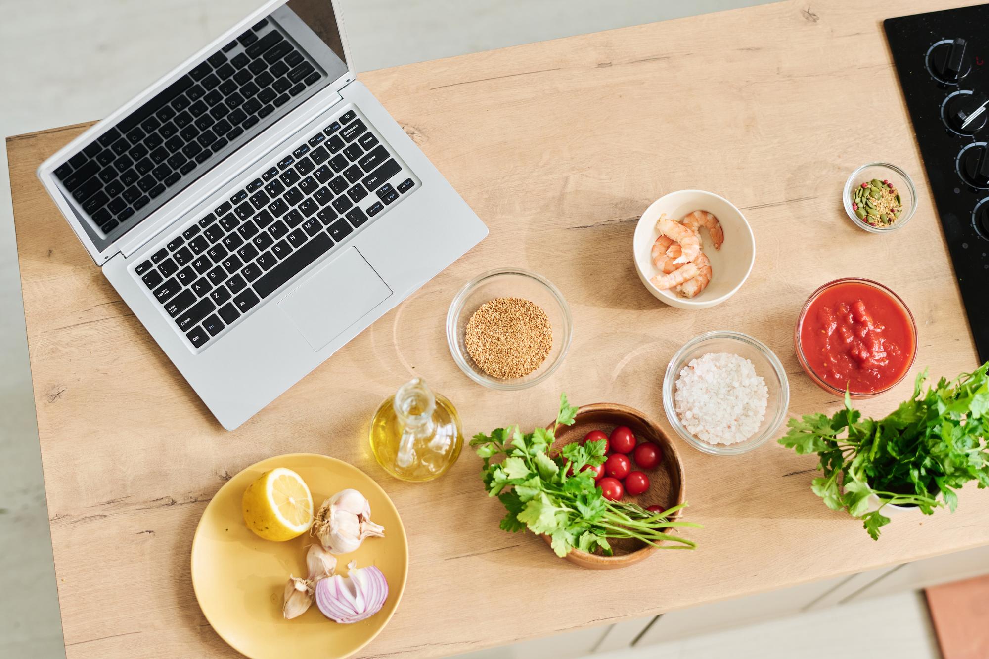 Tavolo cucina con ingredienti e laptop
